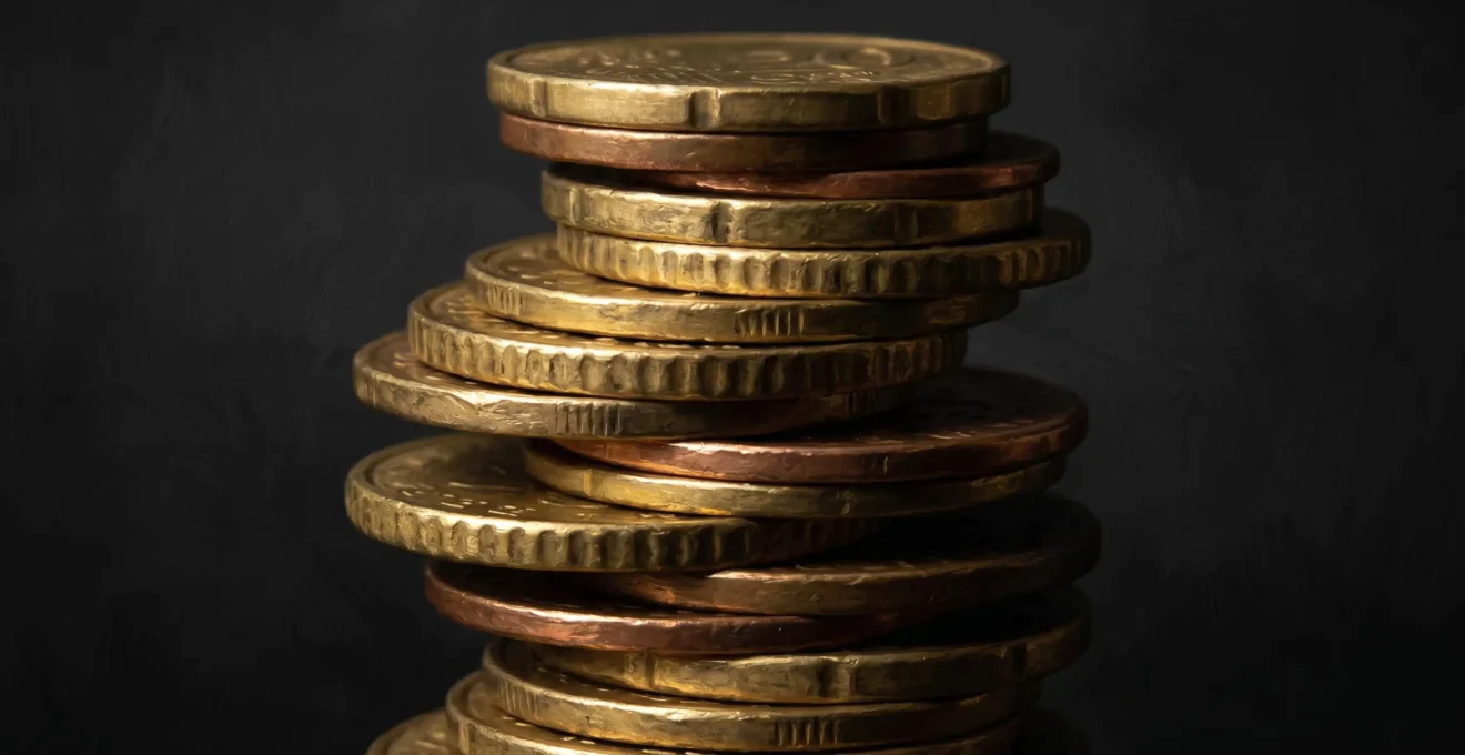 Composition abstraite de pièces de monnaie empilées éclairées par un clair-obscur dramatique